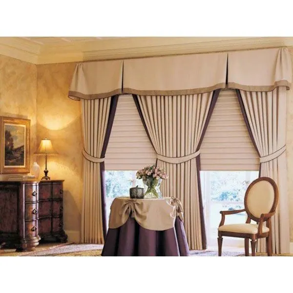 Tailored cream valance, drapes and shade in a warmly lit sitting area