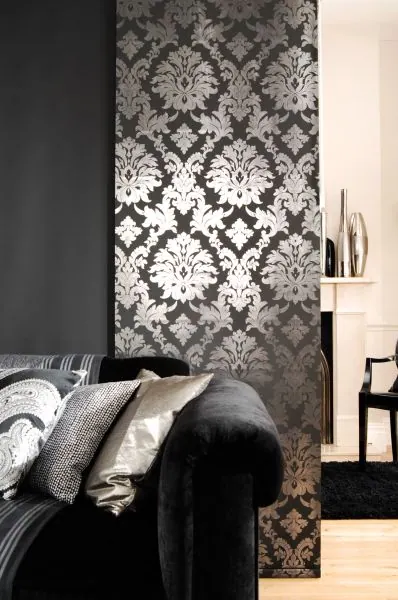 Black sliding panel with silver damask pattern behind a sofa