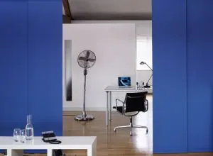 Bright blue sliding panels opening onto a white home office corner