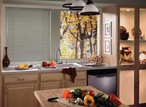 Slim white horizontal blind at a kitchen window with wood cabinets