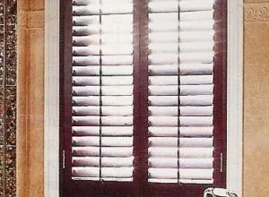 Burgundy-framed shutters with tilted white louvres, close view