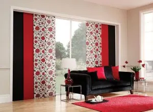 Red, black and white floral sliding panels behind a black sofa