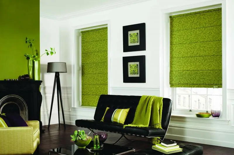 Apple green Roman shades in a white living room with a black sofa