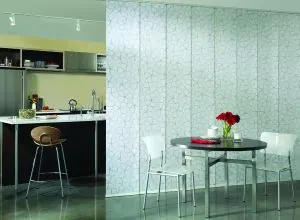 Translucent patterned sliding panels dividing a kitchen and dining area