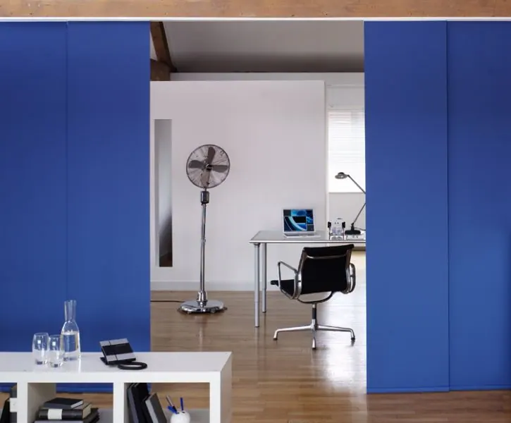 Cobalt blue sliding panels in front of a bright home office