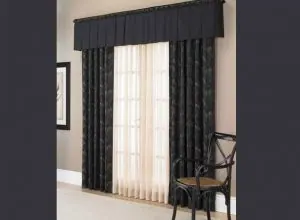 Black embroidered drapes, white sheer and black valance at a patio door