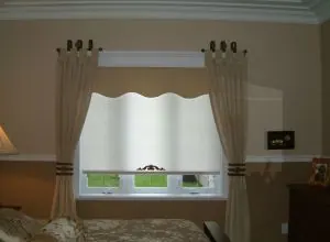 White scalloped-edge shade with cream tab curtains in a bedroom