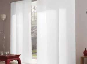 Plain white sliding panels at a window with a red side table