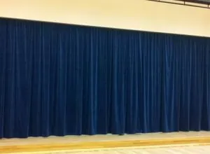 Full-width navy blue pleated stage curtain