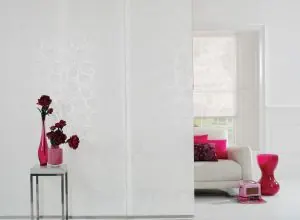 White sliding panels with a subtle pattern beside pink vases