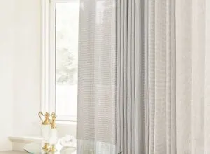 Sheer white and grey striped curtains at a large window