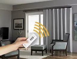 Remote control aimed at grey curtains on a rod in a living room