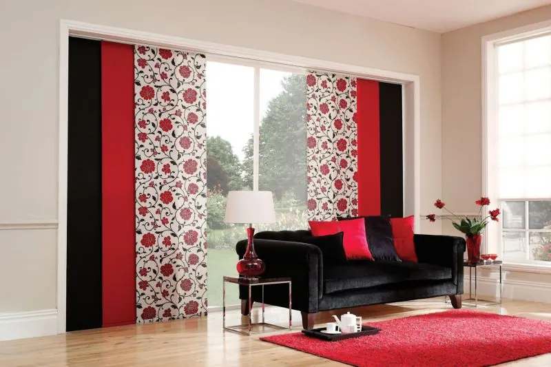 Red, black and floral sliding panels with a black sofa and red rug