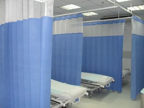 Blue and white privacy curtains between two hospital beds