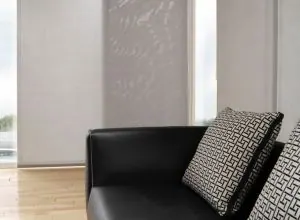Pale grey sliding panel behind a black leather chair with patterned cushion